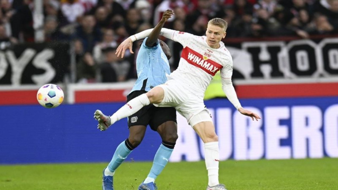 Gelandang VfB Stuttgart Chris Fuehrich (kanan) dan bek Bayer Leverkusen Odilon Kossounou bertarung memperebutkan bola pada pertandingan Liga Jerman yang dimainkan di MHPArena, Stuttgart, Minggu (10/12/2023). (ANTARA/AFP/THOMAS KIENZLE)