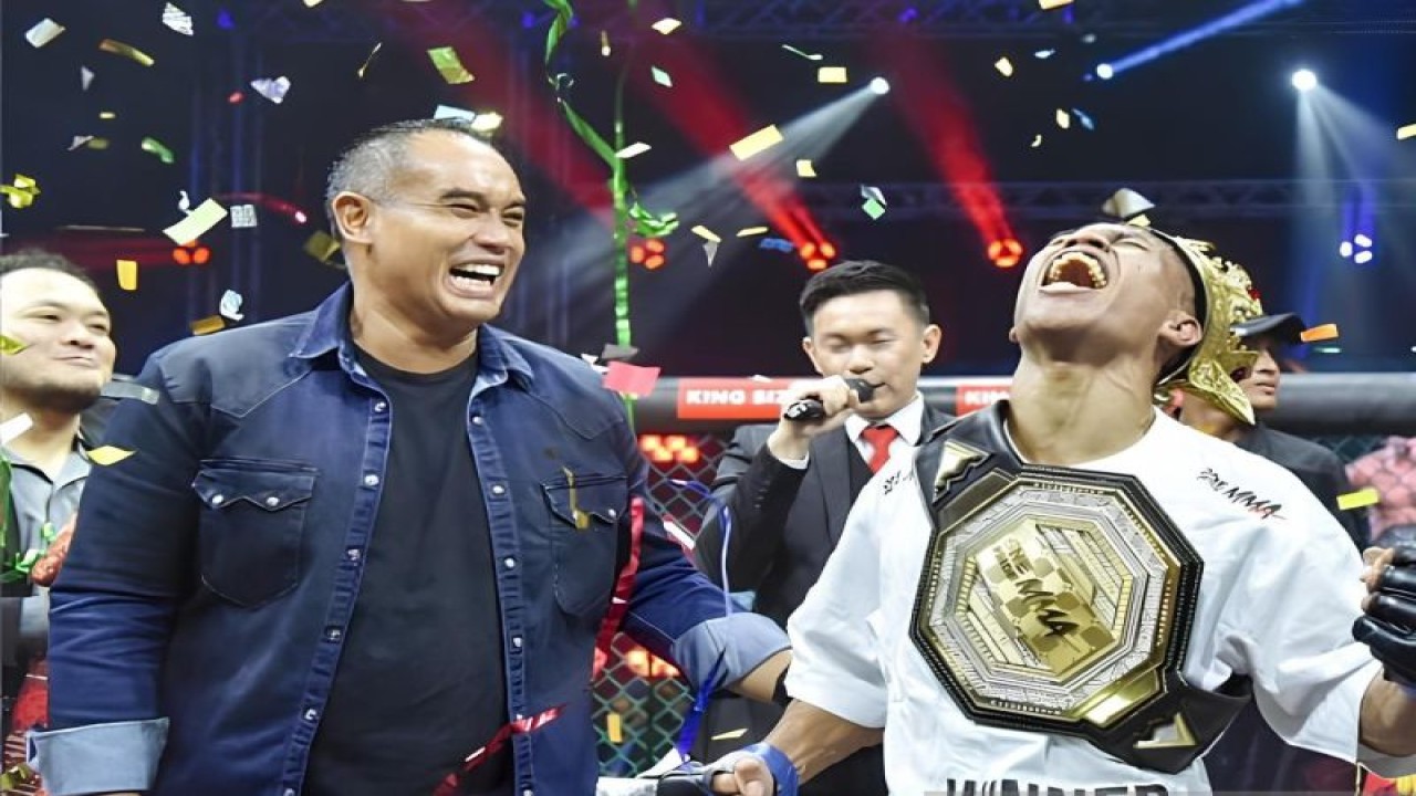 Petarung Mixed Martial Arts (MMA) Lipin Sitorus (kanan) saat dikalungkan gelar juara kelas bulu oleh Ketua Umum KOBI Ardie Bakrie (kiri) dalam gelaran One Pride MMA 75 yang berlangsung di Tennis Indoor Senayan, Jakarta, Sabtu (9/12/2023).(ANTARA/HO-One Pride MMA)