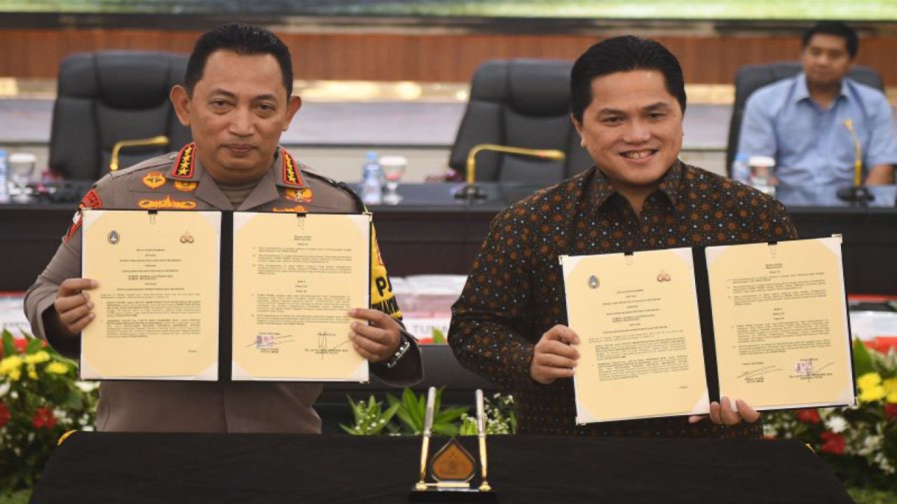 Kapolri Jenderal Pol. Listyo Sigit Prabowo (kiri) dan Ketua Umum PSSI Erick Thohir (kanan) berfoto dengan naskah nota kesepahaman dalam rangka mewujudkan iklim pertandingan olahraga sepak bola yang lebih baik di Mabes Polri, Jakarta, Rabu (13/12/2023). ANTARA FOTO/Aditya Pradana Putra/rwa.