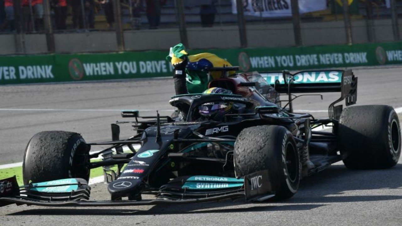 Arsip foto - Pebalap Mercedes Lewis Hamilton melakukan selebrasi dengan mengibarkan bendera Brasil setelah memenangi Grand Prix Sao Paulo, Autodromo Jose Carlos Pace, Interlagos. (14/11/2021) (AFP/NELSON ALMEIDA)