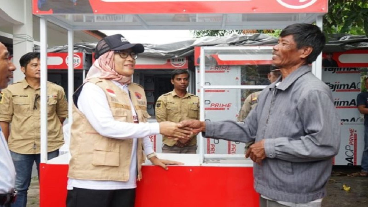 Pj Wali Kota Palangka Raya, Hera Nugrahayu (bertopi) menyerahkan bantuan gerobak pada pelaku UMKM di Palangka Raya. (ANTARA/HO-Dokumentasi Pribadi)