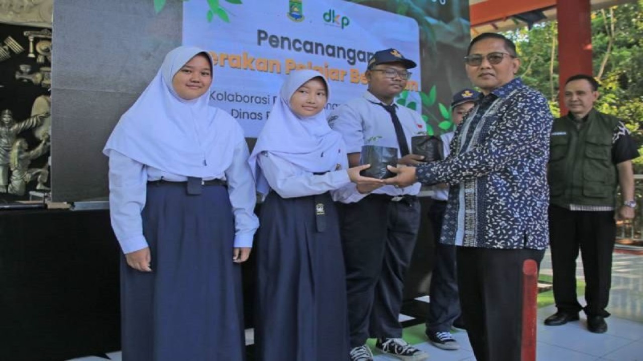 Sekretaris Daerah Kota Tangerang, Herman Suwarman memberikan pohon kepada siswa dalam acara pencanangan gerakan pelajar berkebun SMP Negeri 6 Kota Tangerang, Rabu. ANTARA/HO-Pemkot