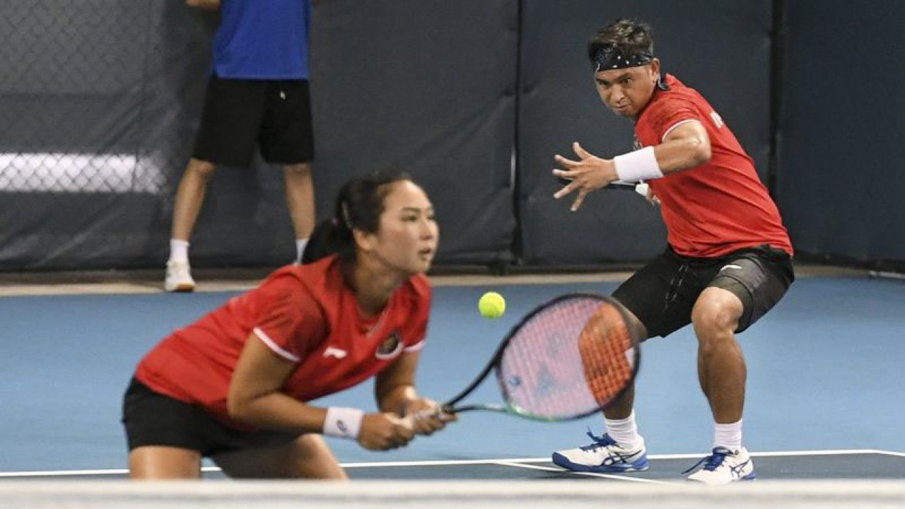 Petenis Indonesia Christopher Rungkat (kanan) dan Aldila Sutjiadi mengembalikan bola ke petenis Thailand Peangtarn Plipuech dan Pruchya Isaro pada babak 16 besar tenis ganda campuran Asian Games 2022 di Hangzhou Olympic Sports Centre Tennis Centre, Hangzhou, China, Rabu (27/9/2023). Aldila dan Rungkat melaju kebabak perempat final setelah menang dengan skor 6-2, 5-7, 10-5. ANTARA FOTO/Hafidz Mubarak A/Spt.
