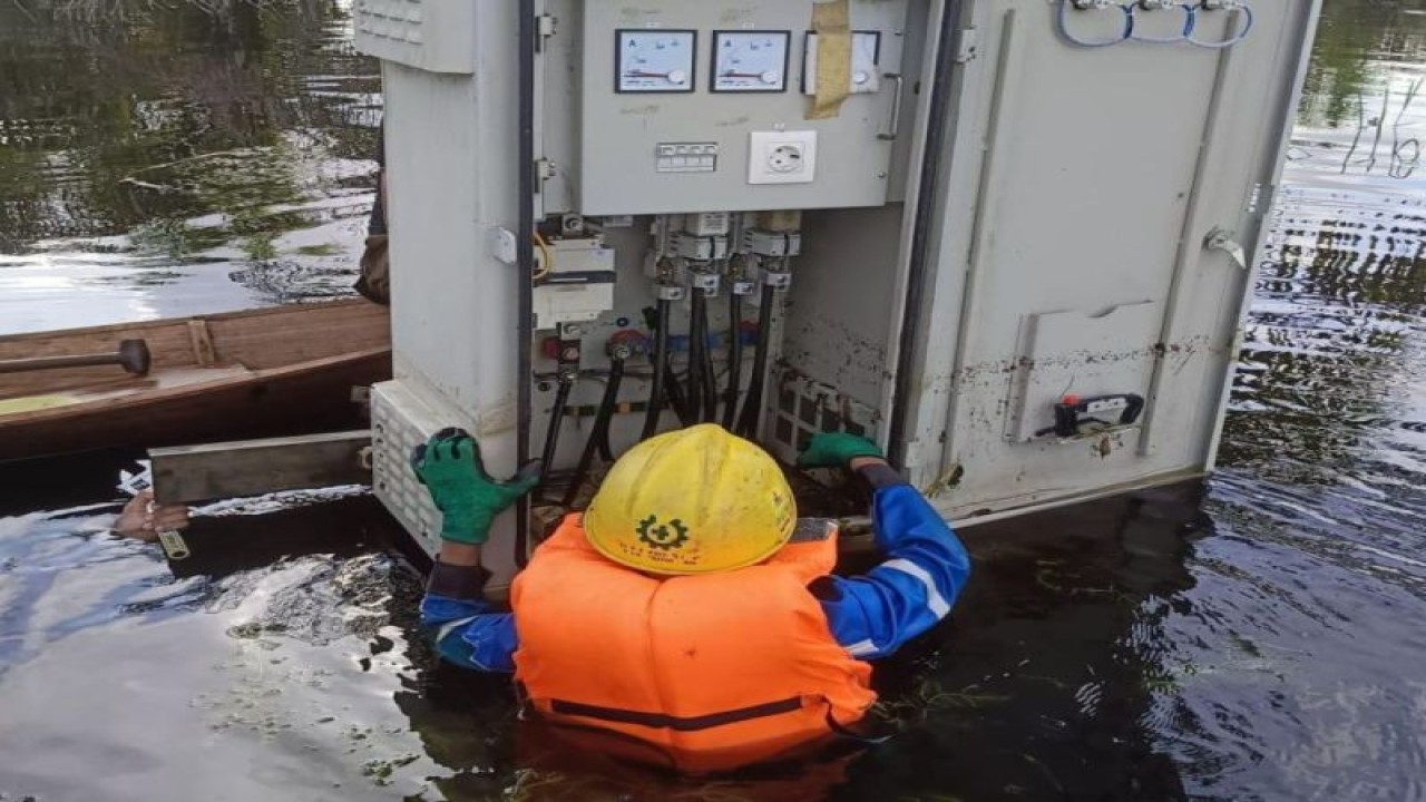 Seorang petugas PLN yang siaga memeriksa gardu distribusi di daerah tertentu yang terendam banjir guna memitigasi risiko bahaya listrik. ANTARA/HO-Humas PLN.