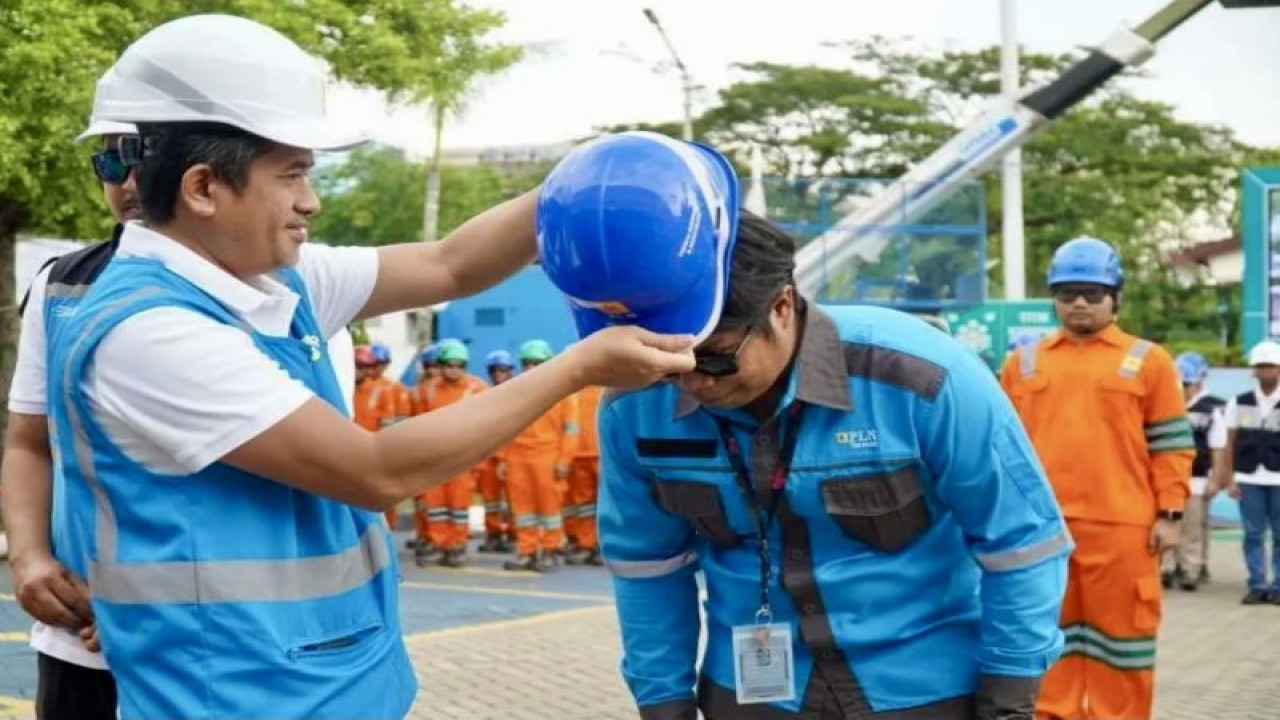 General Manager PLN UID Kalselteng Muhammad Joharifin memasang secara simbolis Alat Pelindung Diri (APD) kepada petugas siaga Pelayanan Teknik (Yantek) pada apel siaga yang dilaksanakan PLN untuk kesiapan menghadapi Natal dan tahun baru serta pemilu 2024, di Kota Banjarmasin, Kalimantan Selatan, beberapa waktu lalu. (ANTARA/HO-PLN Kalselteng)