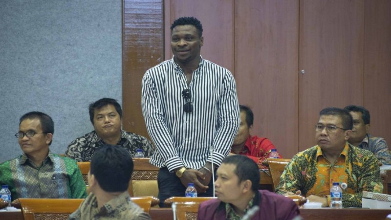Pemain sepak bola warga negara Nigeria, Egwuatu Godstime Ouseloka (tengah) saat diperkenalkan oleh Menpora Imam Nahrawi dalam rapat kerja dengan Komisi X, di Kompleks Parlemen, Senayan, Jakarta, Rabu (16/1/2019). ANTARA FOTO/Aprillio Akbar/ama.