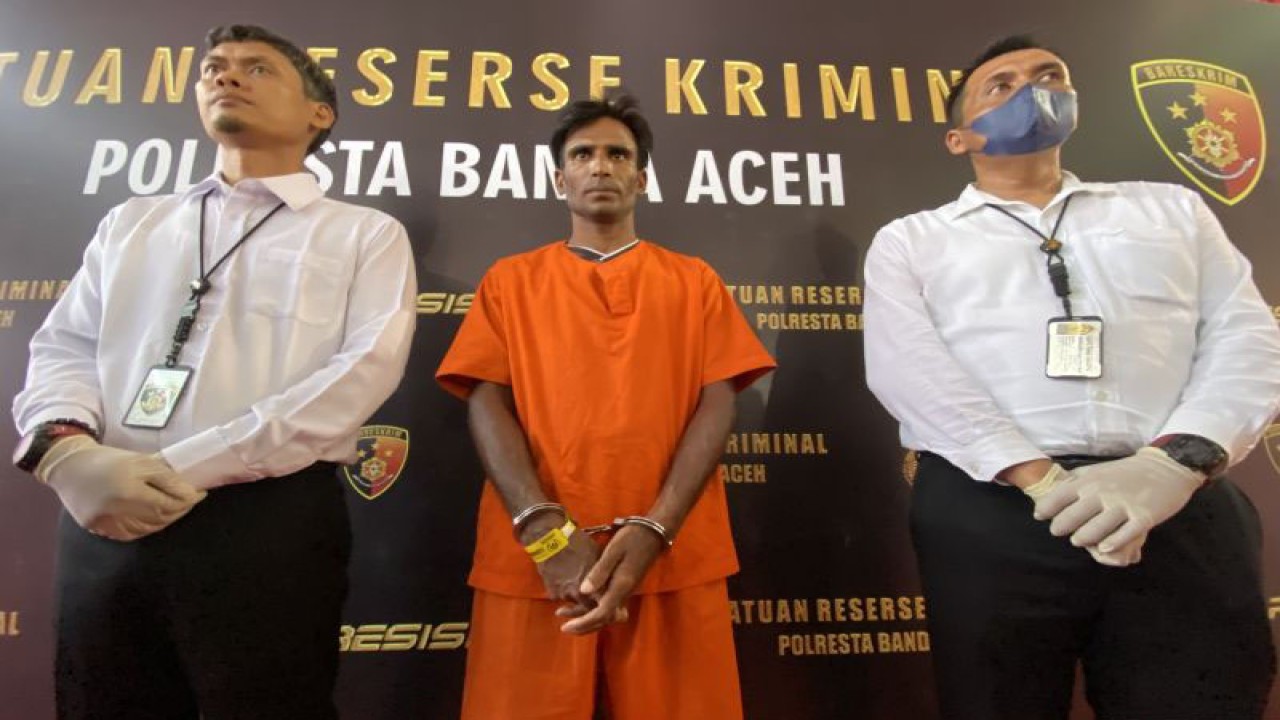 Satreskrim Polresta Banda Aceh mengawal seorang warga etnis Rohingya Muhammed Amin (tengah) yang ditetapkan sebagai tersangka dalam kasus dugaan tindak pidana penyeludupan manusia ke Indonesia di Mapolresta Banda Aceh, Aceh, Senin (18/12/2023). (ANTARA/Khalis)