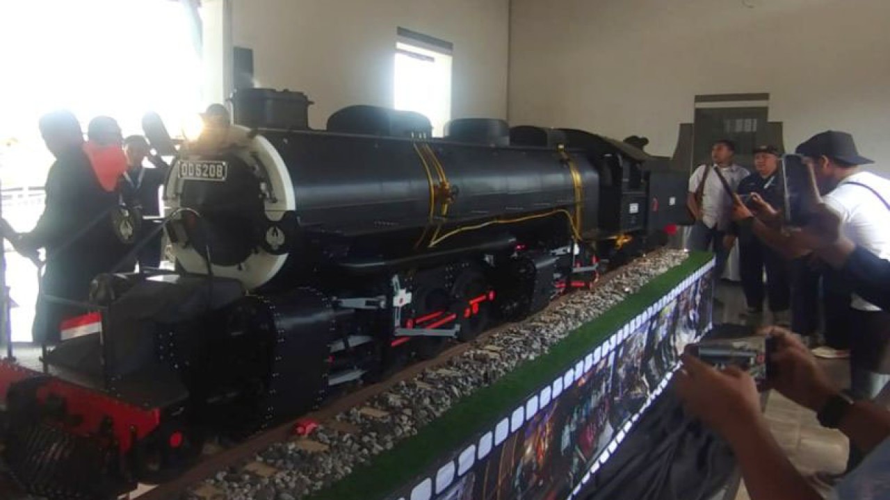 Pengunjung melihat miniatur lokomotif uap yang dipamerkan di Stasiun Garut, Kabupaten Garut, Jawa Barat, Jumat (15/12/2023). (ANTARA/Feri Purnama)