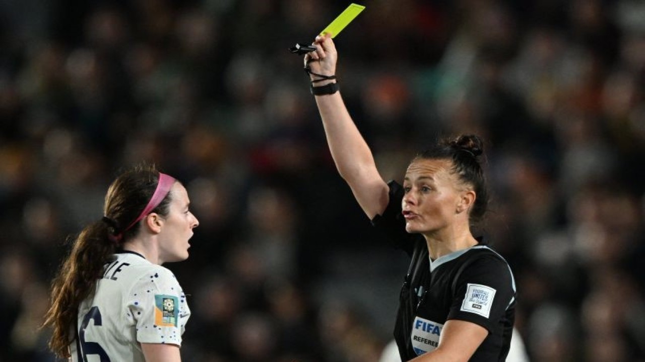 Arsip - Wasit Inggris Rebecca Welch (kanan) memberikan kartu kuning kepada gelandang AS Rose Lavelle (kiri) pada pertandingan Grup E Piala Dunia Putri 2023, yang dimainkan di Eden Park, Auckland, Selandia Baru, 1 Agustus 2023. (ANTARA/AFP/SAEED KHAN)
