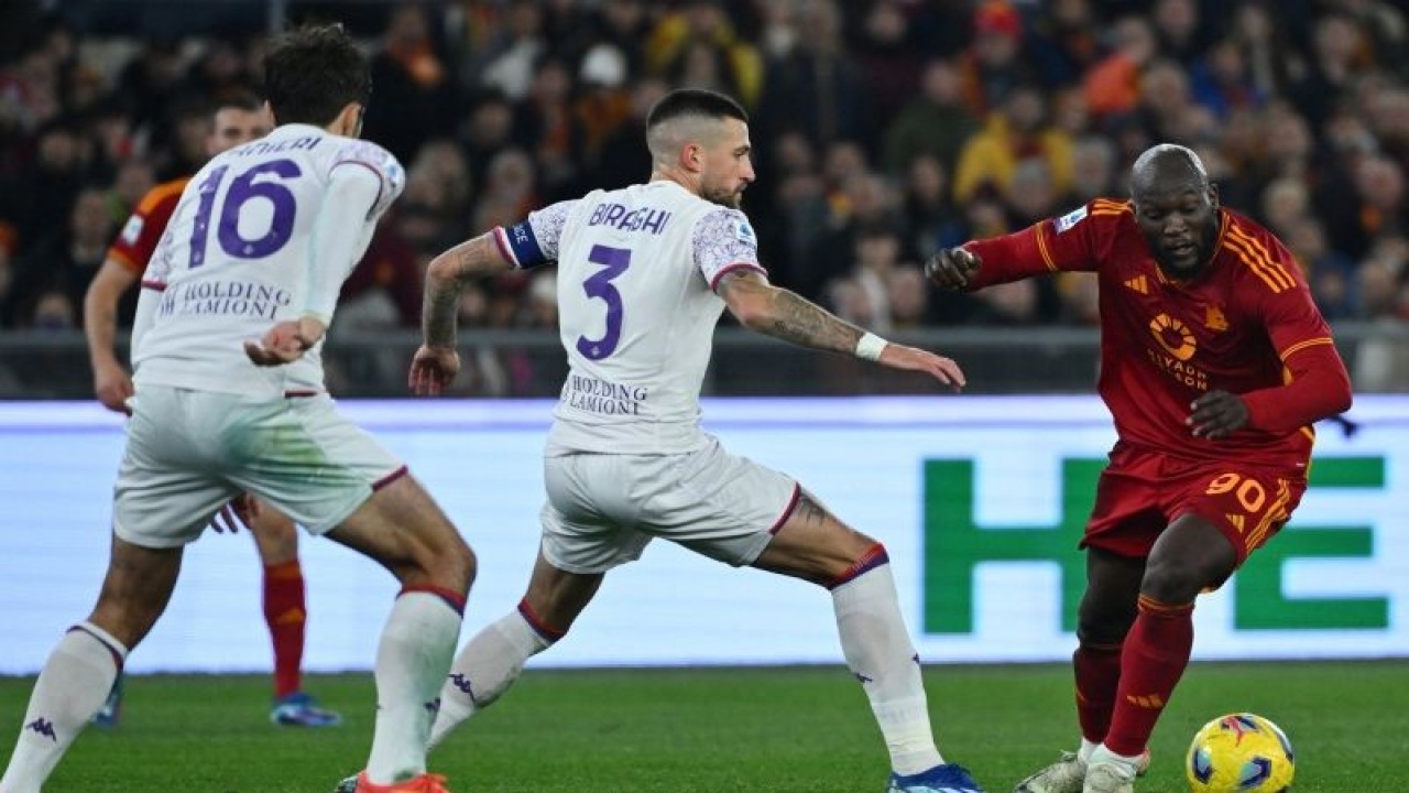 Gelandang AS Roma Romelu Lukaku (kanan) mencoba melewati bek Fiorentina (tengah) Cristiano Biraghi pada pertandingan Liga Italia yang dimainkan di Stadion Olimpico, Roma, Minggu (10/12/2023). (ANTARA/Alberto PIZZOLI / AFP (AFP)