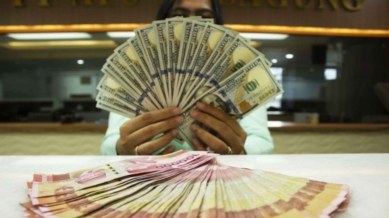 Teller memegang mata uang Dolar AS dan Rupiah di sebuah tempat penukaran uang, Jakarta, Rabu (6/7/2022). Kurs Rupiah ditutup Rp14.999 per Dolar AS pada perdagangan Rabu (6/7) hari ini, melemah 0,03 persen ketimbang posisi penutupan perdagangan kemarin (5/7) pada Rp 14.994 per dolar AS. (ANTARA FOTO/Subur Atmamihardja/wsj/foc.)