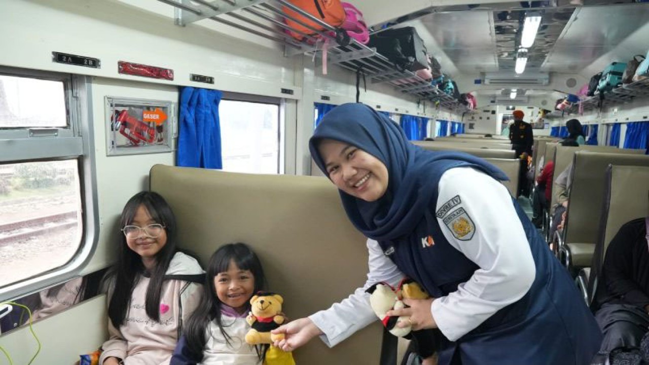 Petugas PT KAI Divre IV Tanjungkarang membagikan souvernir kepada pelanggan kereta api. ANTARA/Edo Purmana/23