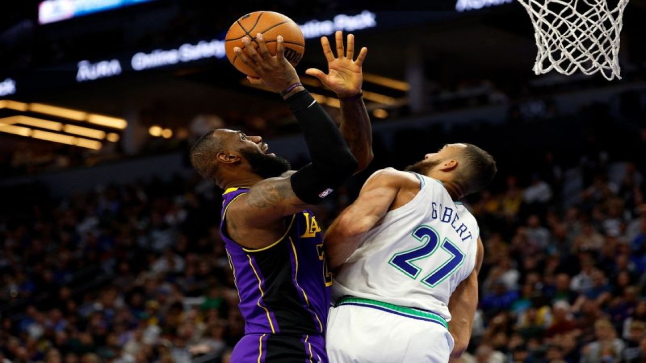 Bintang Los Angeles Lakers LeBron James (kiri) berupaya memasukan bola ke dalam keranjang sambil dibayangi oleh pemain Minnesota Timberwolves Rudy Gobert dalam laga NBA yang digelar di Target Center Minneapolis, Minnesota. ANTARA/AFP