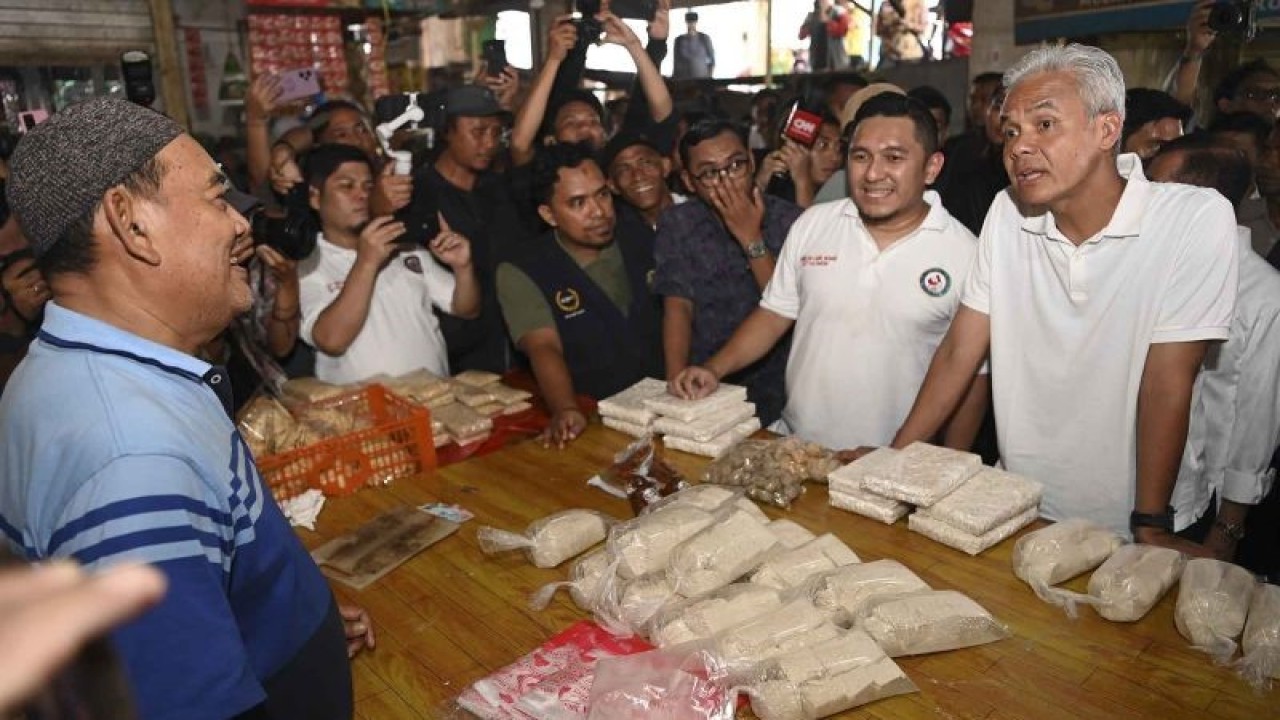 Calon Presiden nomor urut 3 Ganjar Pranowo (kanan) berbincang dengan pedagang tempe saat mengunjungi Pasar Baru, Klandasan Ilir, Balikpapan, Kalimantan Timur, Selasa (5/12/2023). Dalam kesempatan tersebut Ganjar Pranowo berdialog dengan pengemudi ojek, pedagang sayur mayur hingga membeli dagangannya berupa cabai dan tempe. ANTARA FOTO/M Risyal Hidayat/nym.