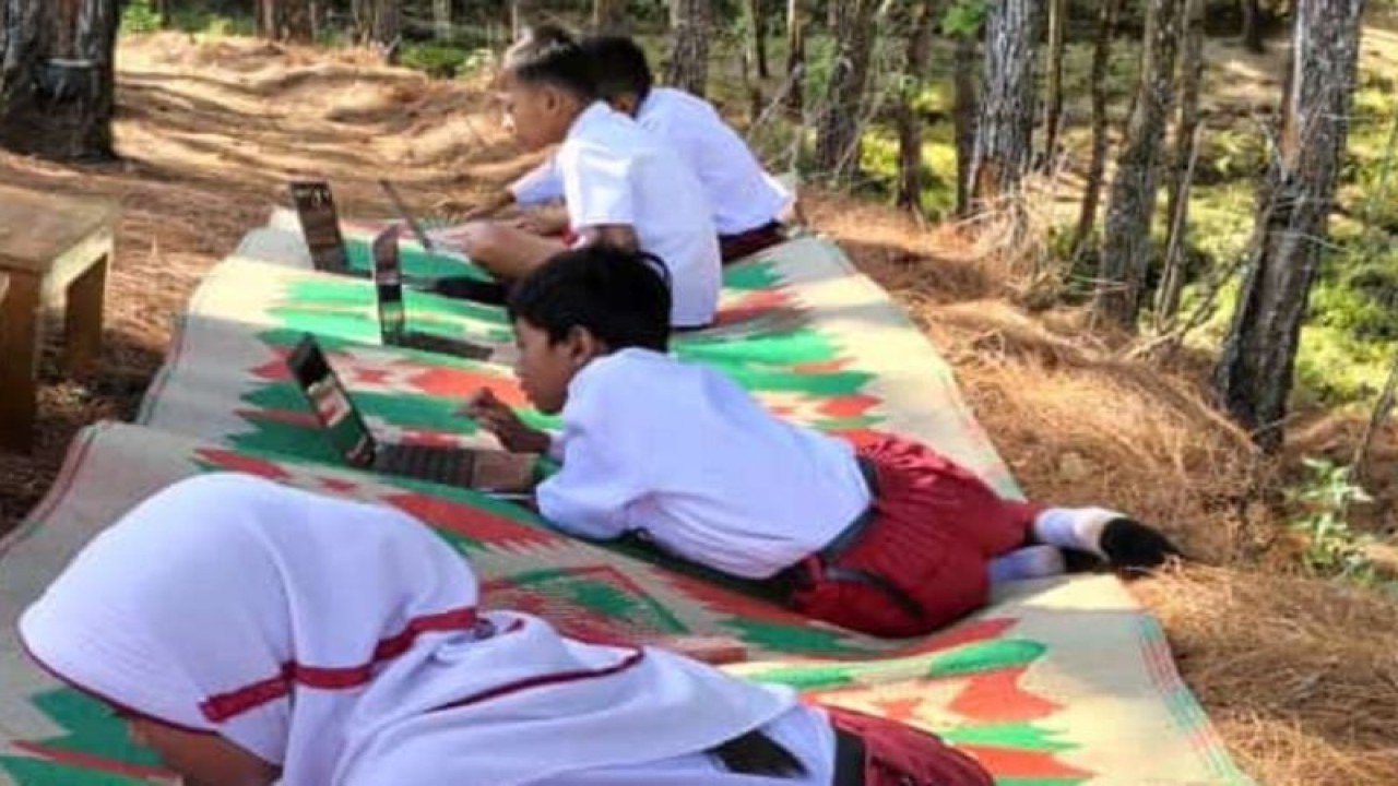 Siswa mengerjakan ujian daring di pinggiran hutan yang terdapat sinyal internet di wilayah pedalaman Kecamatan Bendungan, Trenggalek. (ANTARA/HO - foto warga)