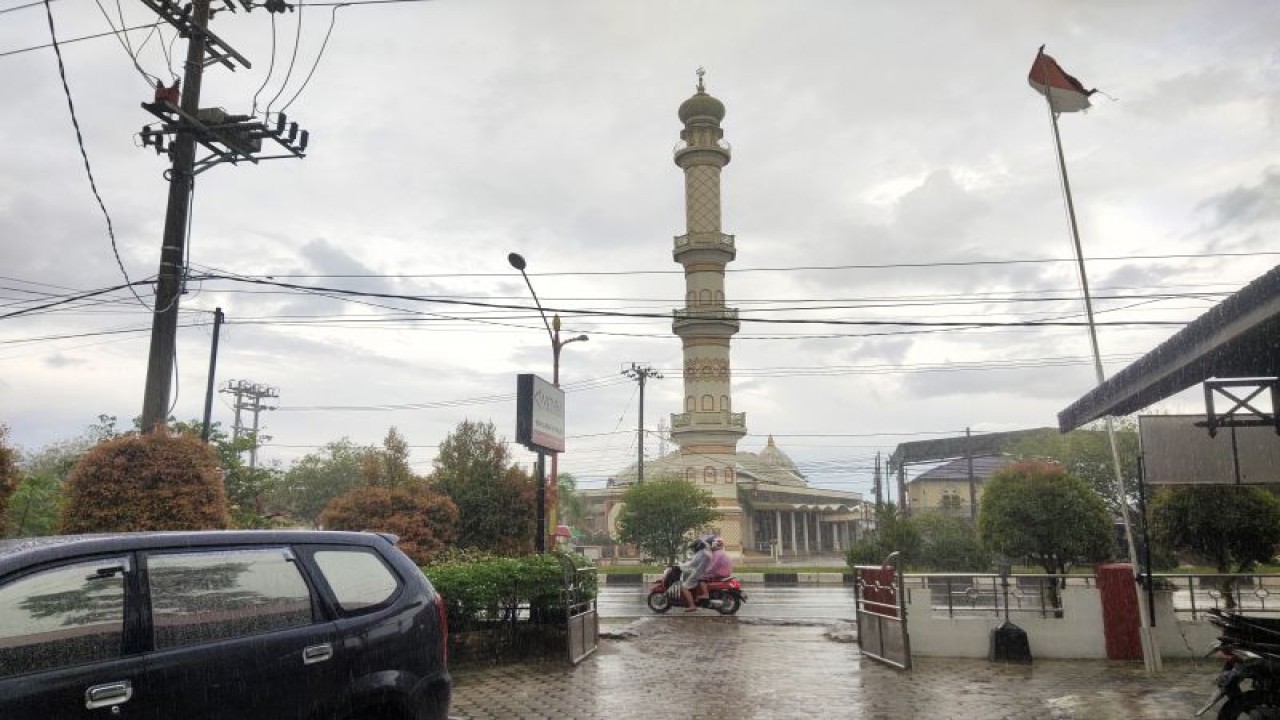 Warga beraktivitas saat hujan lebat mengguyur wilayah Kota Palangka Raya, Kalimantan Tengah. (ANTARA/Rendhik Andika)
