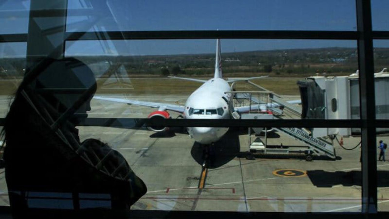 Pemudik melintas di depan pesawat yang sedang parkir di Apron bandara El Tari Kupang. ANTARA/Kornelis Kaha