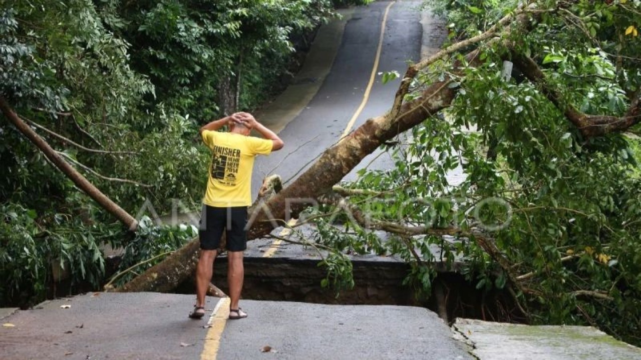 Arsip - Wisatawan saat melihat badan jalan yang terputus akibat longsor di jalan kilometer nol, Iboih, Sabang, Aceh, Senin (30/1/2023). ANTARA FOTO/Irwansyah Putra.
