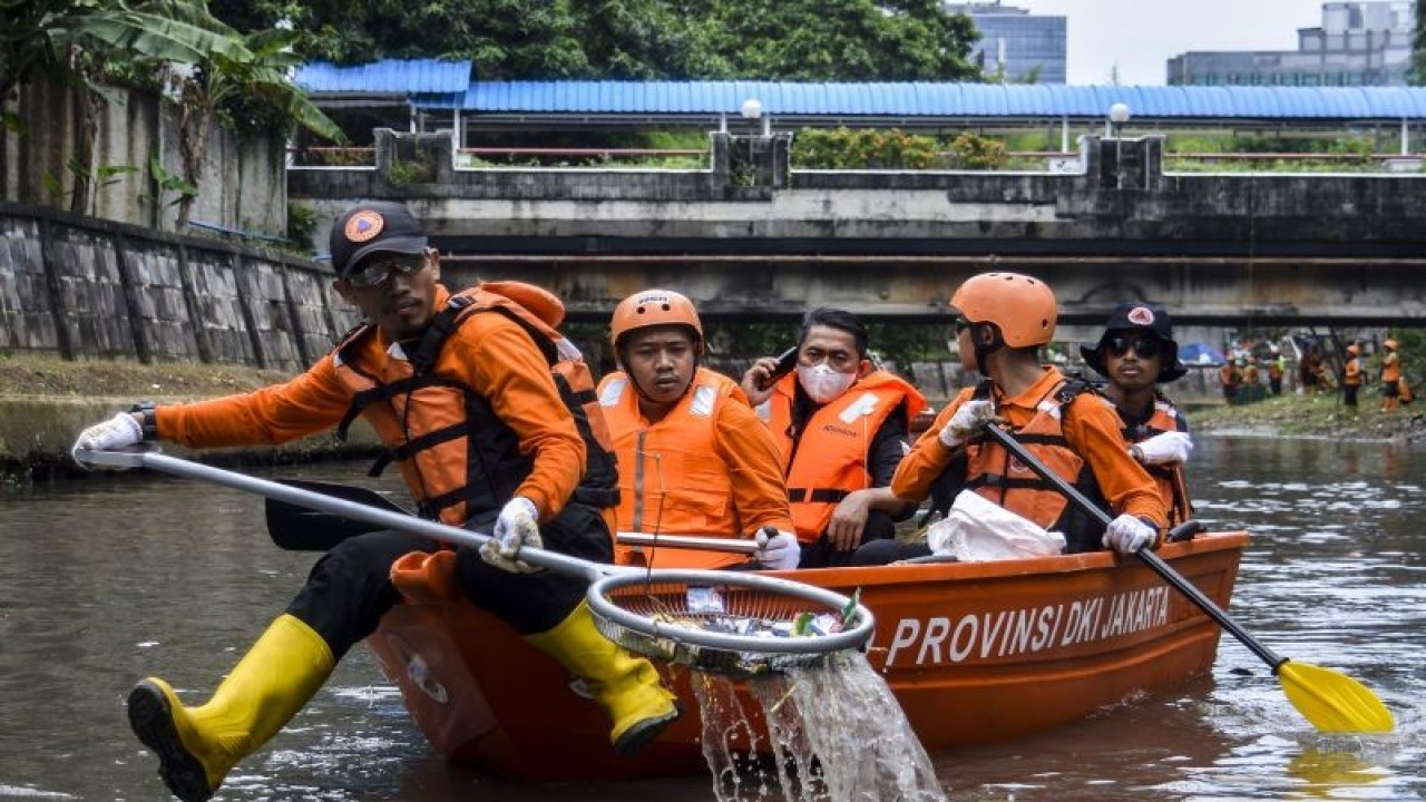 Sejumlah petugas Badan Penanggulangan Bencana Daerah (BPBD) DKI Jakarta mengambil sampah saat kerja bakti gabungan di Kali Ciliwung, Jakarta, Kamis (10/11/2022). Pemerintah Provinsi DKI Jakarta mengadakan kegiatan Kerja Bakti Gabungan di lima titik lokasi serta menyusuri Kali Ciliwung bersama Pasukan KOSTARD, KOPASSUS, MARINIR, BRIMOB, dan masyarakat. ANTARA FOTO/Sulthony Hasanuddin/foc.