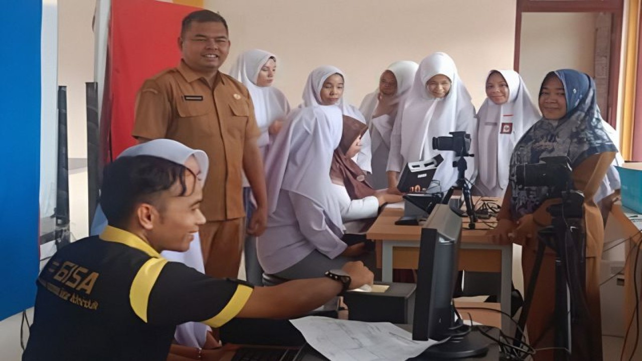 Disdukcapil Pasaman Barat saat melakukan perekaman KTP elektronik di salah satu sekolah di daerah itu. Selain jemput bola ke sekolah, dinas terkait juga membuka layanan pada Sabtu dan Minggu. Antara/HO-Disdukcapil Pasaman Barat.