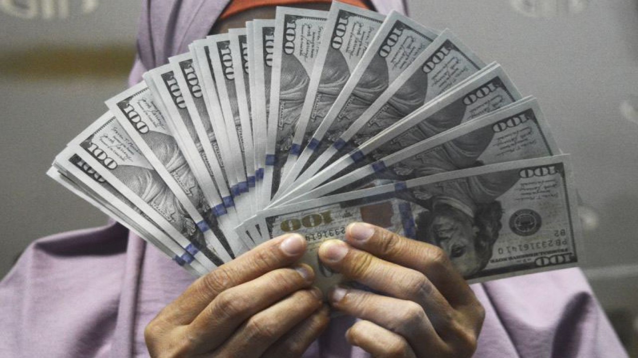 Petugas menunjukkan uang dolar AS di salah satu gerai penukaran uang asing di Jakarta, Selasa (10/10/2023). ANTARA FOTO/Bagus Ahmad Rizaldi/sgd/YU