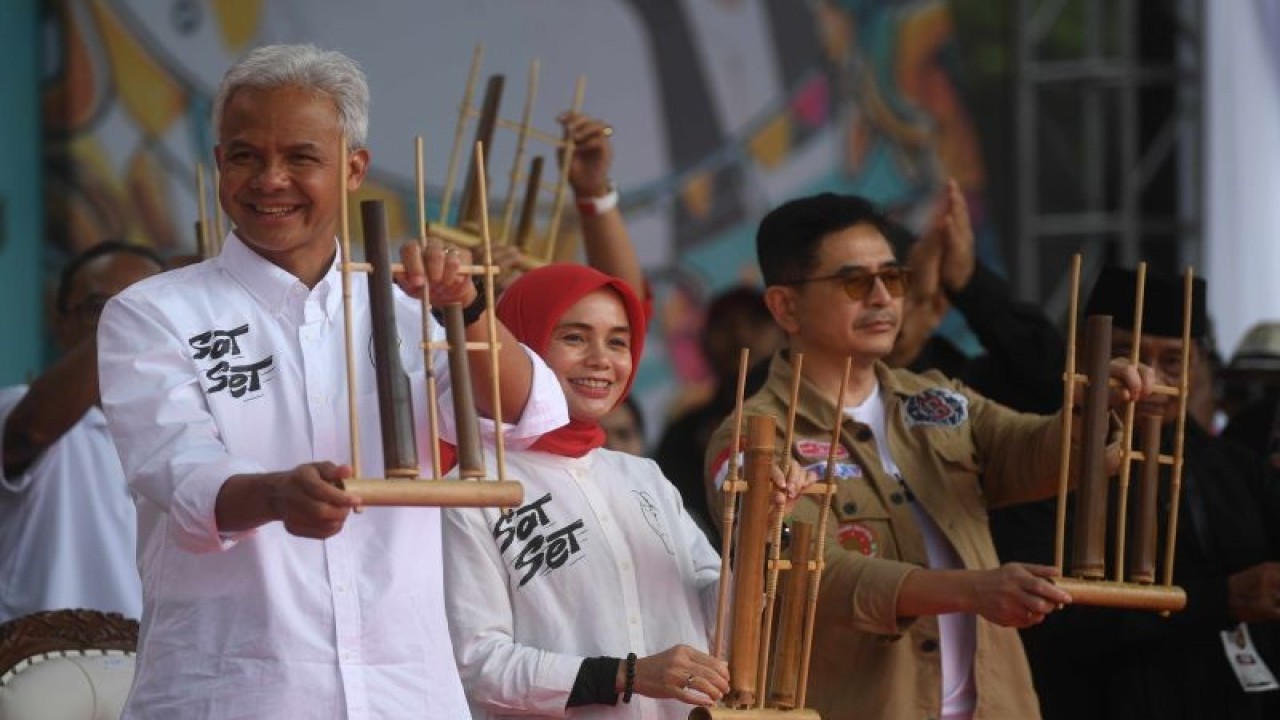 Calon presiden nomor urut 3 Ganjar Pranowo (kiri) bersama istri Siti Atikoh (tengah) dan Ketua Tim Pemenangan Nasional Arsjad Rasjid (kanan) memainkan angklung saat kampanye terbuka perdana bertajuk Hajatan Rakyat di Lapangan Tegalega, Bandung, Jawa Barat, Minggu (21/1/2024). (ANTARA FOTO/Akbar Nugroho Gumay/wpa