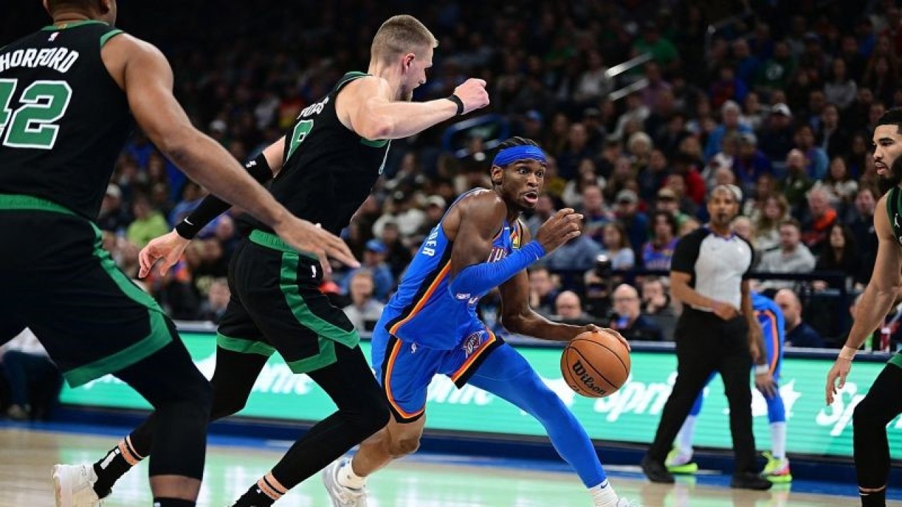 Pemain Oklahoma City Thunder Shai Gilgeous-Alexander (tengah) berusaha melewati adangan lawan pada pertandingan NBA melawan Boston Celtics, yang dimainkan di Paycom Center Oklahoma City, Selasa (2/1/2024). (ANTARA/AFP/JOSHUA GATELEY)