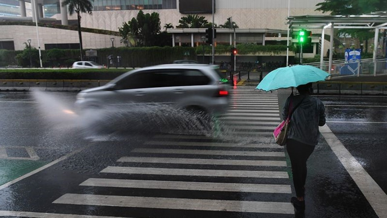 Arsip foto - Warga berjalan sambil membawa payung saat hujan di kawasan Bundaran Hotel Indonesia, Jakarta. ANTARA FOTO/Akbar Nugroho Gumay/wsj/aa.