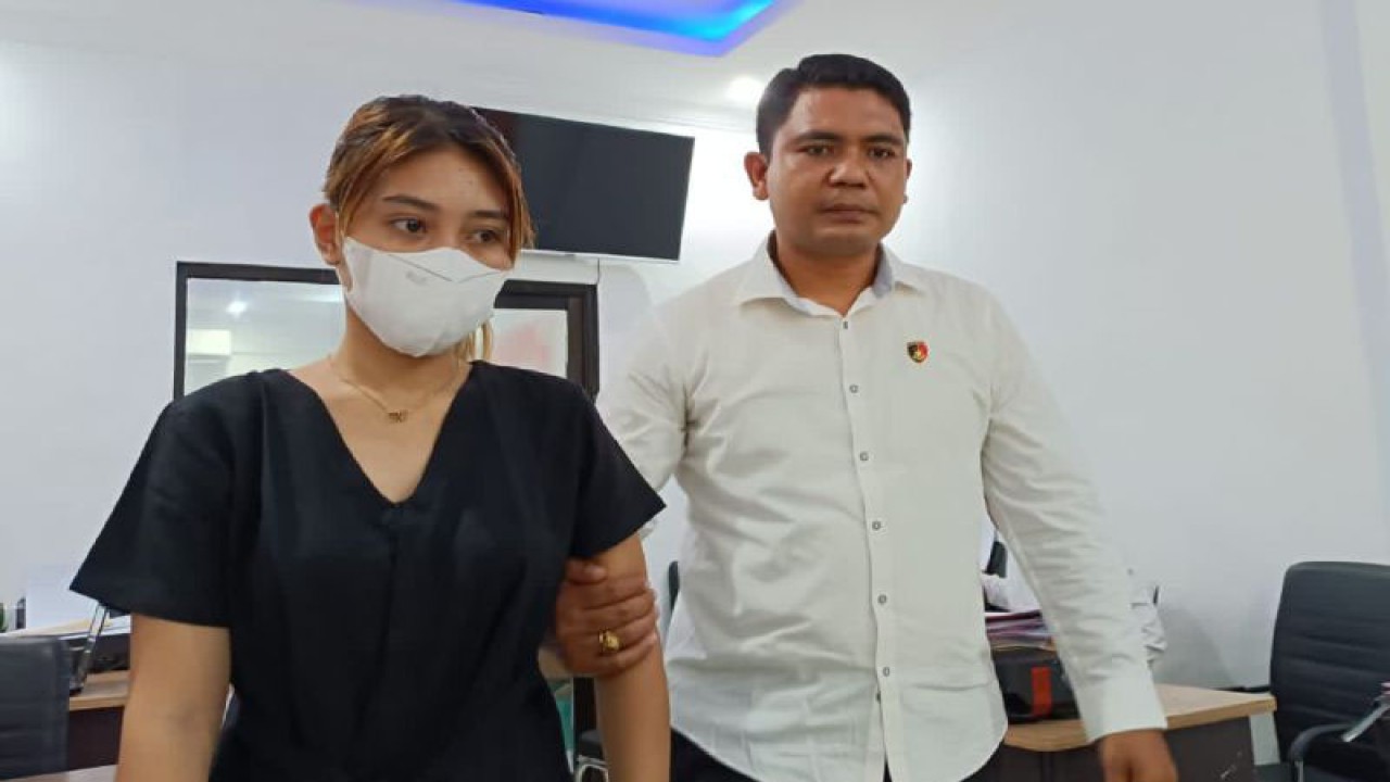 Petugas kepolisian mengawal "influencer" yang menjadi tersangka kasus dugaan penipuan modus arisan daring berinisial BEY (kiri) untuk menjalani pemeriksaan penyidik di Polresta Mataram, NTB, Selasa (16/1/2024). ANTARA/Dhimas B.P.