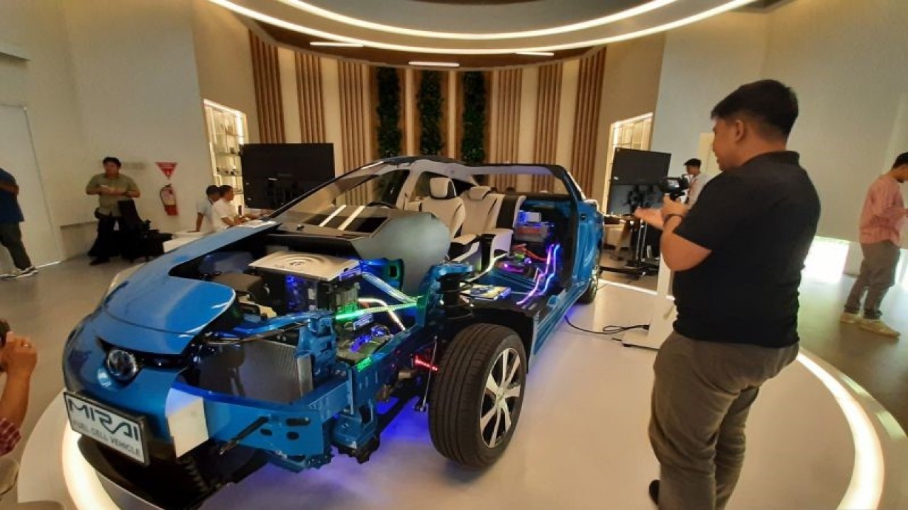 Seseorang mengabadikan gambar Toyota Mirai berbahan hidrogen atau Fuel Cell Electric Vehicle (FCEV) di xEV Center milik PT Toyota Motor Manufacturing Indonesia (TMMIN) di Karawang, Jawa Barat, Senin (22/1/2024). (ANTARA/Lia Wanadriani Santosa)
