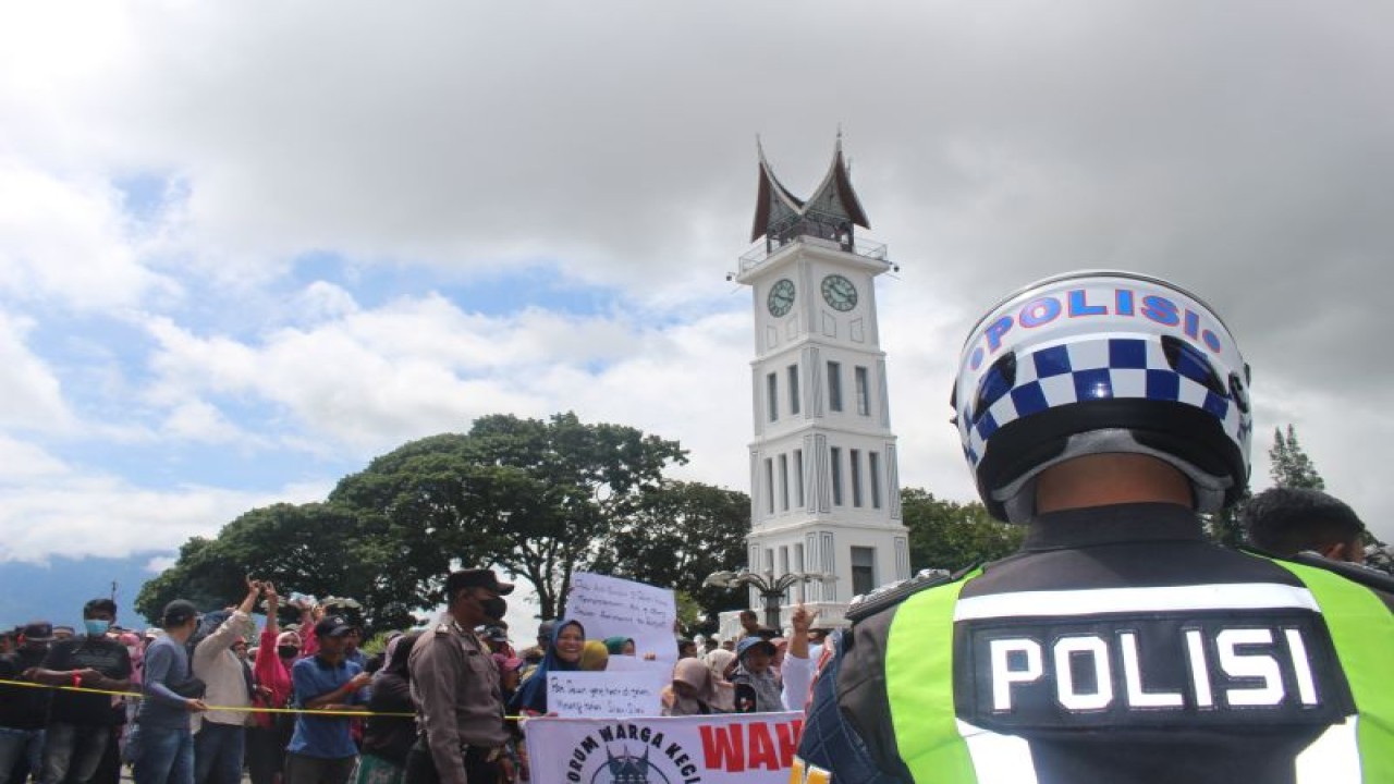 Petugas kepolisian dengan latar belakang Jam Gadang Kota Bukittinggi. Polresta Bukittinggi memburu pelaku penyelundupan ganja ke Lapas Bukittinggi. (Antara/Altas Maulana).