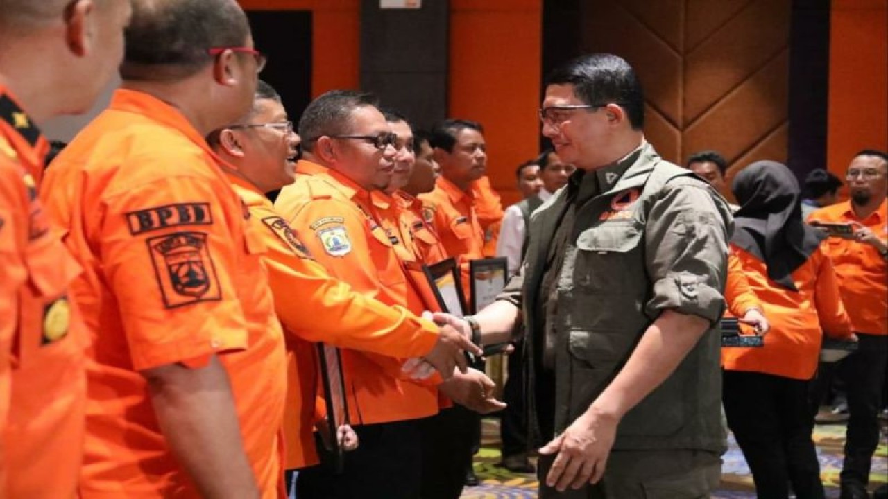 Kepala BNPB Letjen TNI Suharyanto (kemeja dan rompi hijau) menyerahkan secara simbolis Bantuan Operasional Dana Siap Pakai (DSP) untuk penanganan darurat bencana hidrometeorologi kepada Kepala Pelaksana BPBD Kabupaten/Kota se-Jawa Timur, Selasa (16/1/2024). (Antara/HO-BNPB)