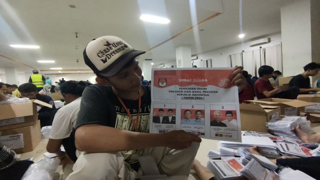 Seorang petugas menunjukan surat suara calon presiden dan calon wakil presiden dalam kegiatan sortir dan lipat di GOR Grogol Petamburan, Jakarta Barat, Kamis (11/1/2024). ANTARA/Risky Syukur
