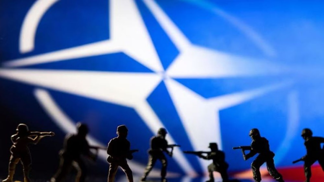 Patung-patung tentara dipajang di depan logo NATO.Kredit: (Reuters)