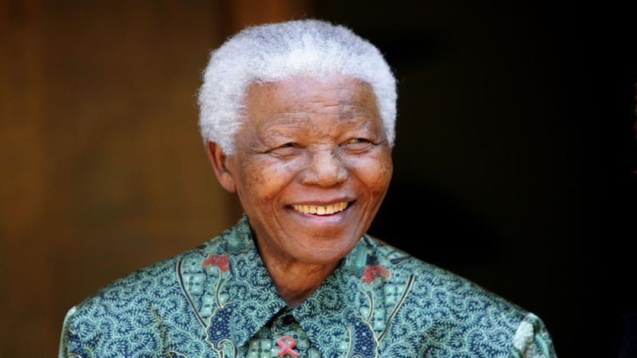 Mantan Presiden Afrika Selatan Nelson Mandela tersenyum kepada pewarta foto setelah pertemuan dengan aktor Tim Robbins di rumahnya di Johannesburg, pada 22 September 2005. (Mike Hutchings/Reuters)