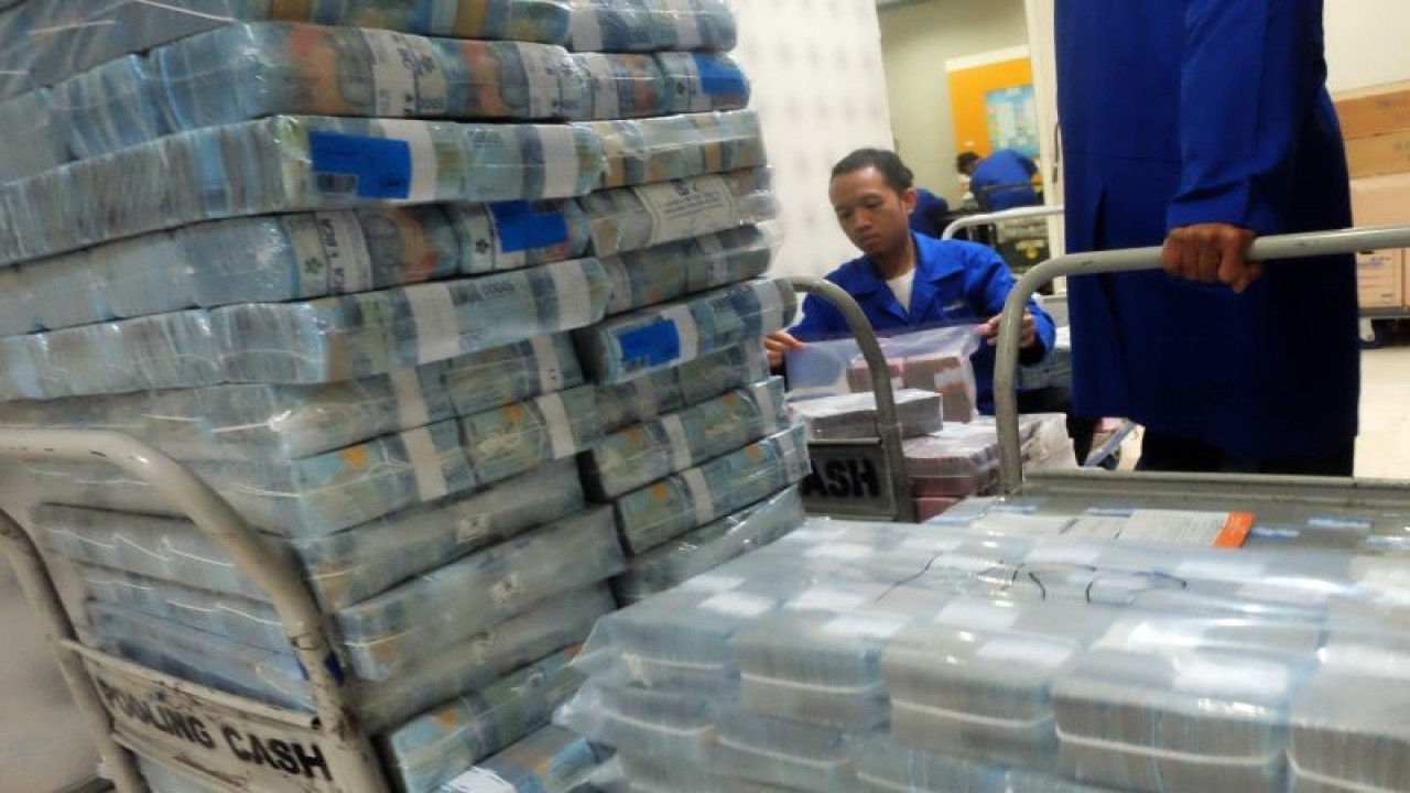 Petugas memindahkan tumpukan uang tunai di Pooling Cash Plaza Mandiri, Jakarta Selatan, Selasa (9/1/2024). Bank Indonesia (BI) mencatat posisi cadangan devisa Indonesia sebesar 146,4 miliar dolar AS pada akhir Desember 2023 atau meningkat dibandingkan dengan posisi pada akhir November 2023 yang sebesar 138,1 miliar dolar AS. ANTARA FOTO/Rizka Khaerunnisa/sgd/tom.