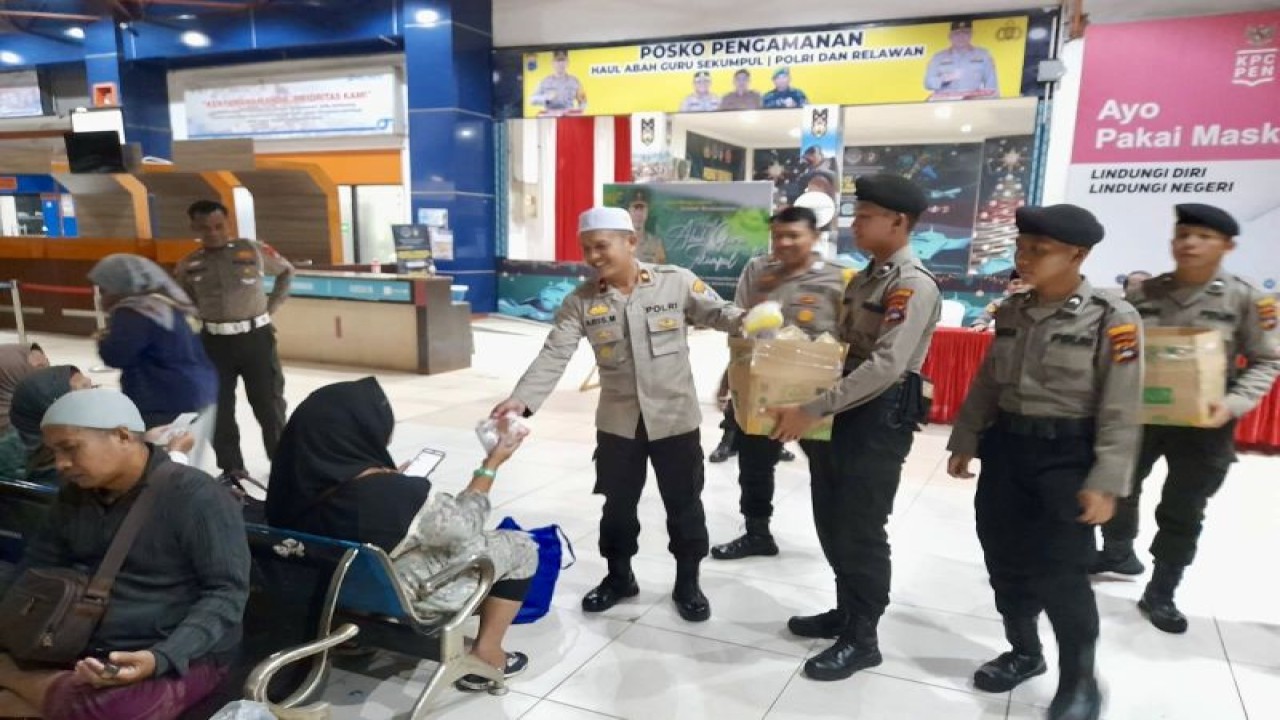 Jajaran Polresta Banjarmasin saat menyapa salah satu jamaah Haul Guru Sekumpul yang akan pulang ke Pulau Jawa, di Pelabuhan Trisakti Banjarmasin, Kalimantan Selatan, Senin (15/1/2024). (ANTARA/HO-Polresta Banjarmasin)