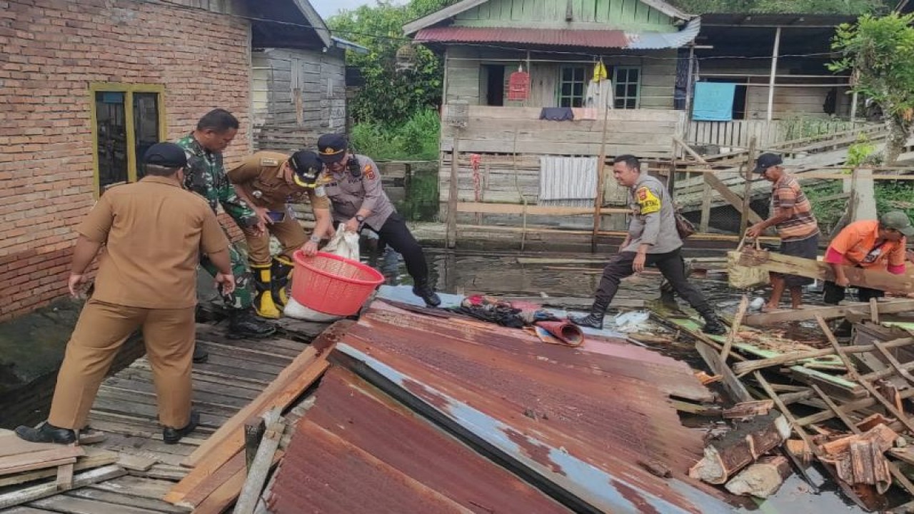 Personel Polresta Jambi mengevakuasi warga yang rumahnya terendam air akibat luapan Sungai Batanghari, Senin (29/1/2024). (ANTARA/HO-Polresta Jambi)