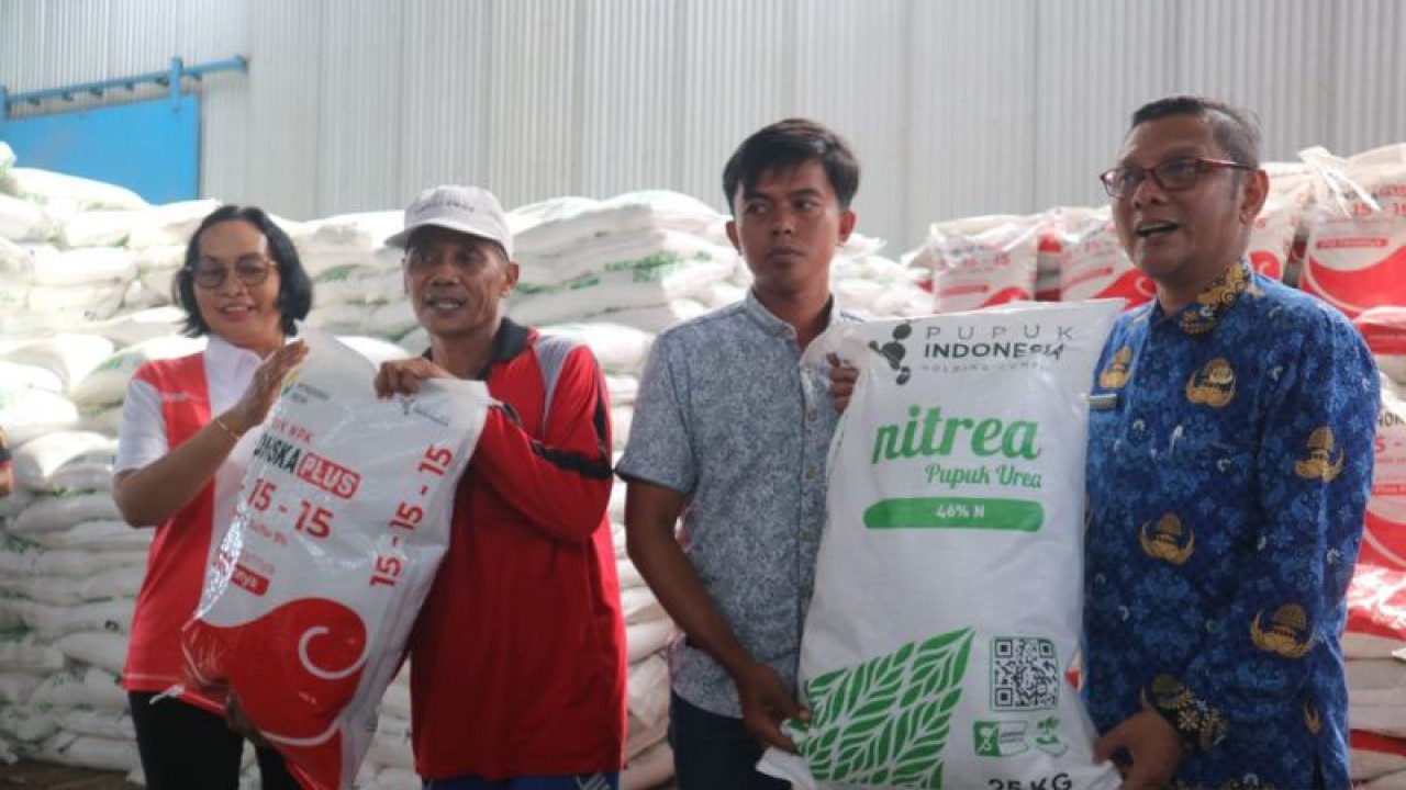 Direktur Operasi dan Produksi PT Petrokimia Gresik Digna Jatiningsih bersama Kepala Dinas Ketahanan Pangan dan Pertanian Kabupaten Ngawi Supardi menyerahkan Pupuk Nitrea Urea 25 kilogram dan NPK Phonska Plus 25 kilogram kepada petani yang dijual dalam kegiatan Gebyar Pasar Pupuk Murah, di Gudang Pupuk Sidokerto, Jalan Raya Ngawi-Caruban, Kecamatan Karangjati, Kabupaten Ngawi, Jawa Timur, Rabu (17/1/2024). ANTARA/Louis Rika