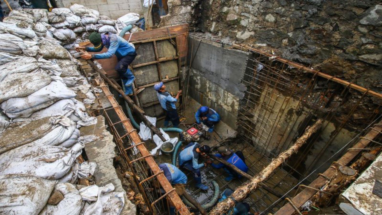 Pekerja menyelesaikan pembuatan saluran air di Rawa Buaya, Jakarta, Selasa (14/9/2021). Pemkot Jakarta Barat membuat sejumlah kebijakan penanganan banjir di lima lokasi prioritas, salah satunya di Rawa Buaya dengan membersihkan sampah di Kali Mookervart dan membangun saluran gendong sepanjang 1.008 meter persegi. ANTARA FOTO/Rivan Awal Lingga/foc.