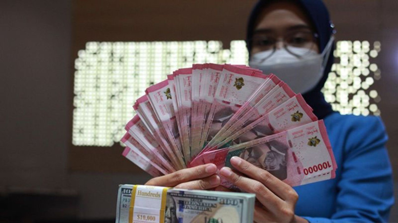 Petugas perbankan menunjukkan uang dolar AS dan uang rupiah, Jakarta, Selasa (31/1/2023). (ANTARA FOTO/Reno Esnir/tom/aa.)