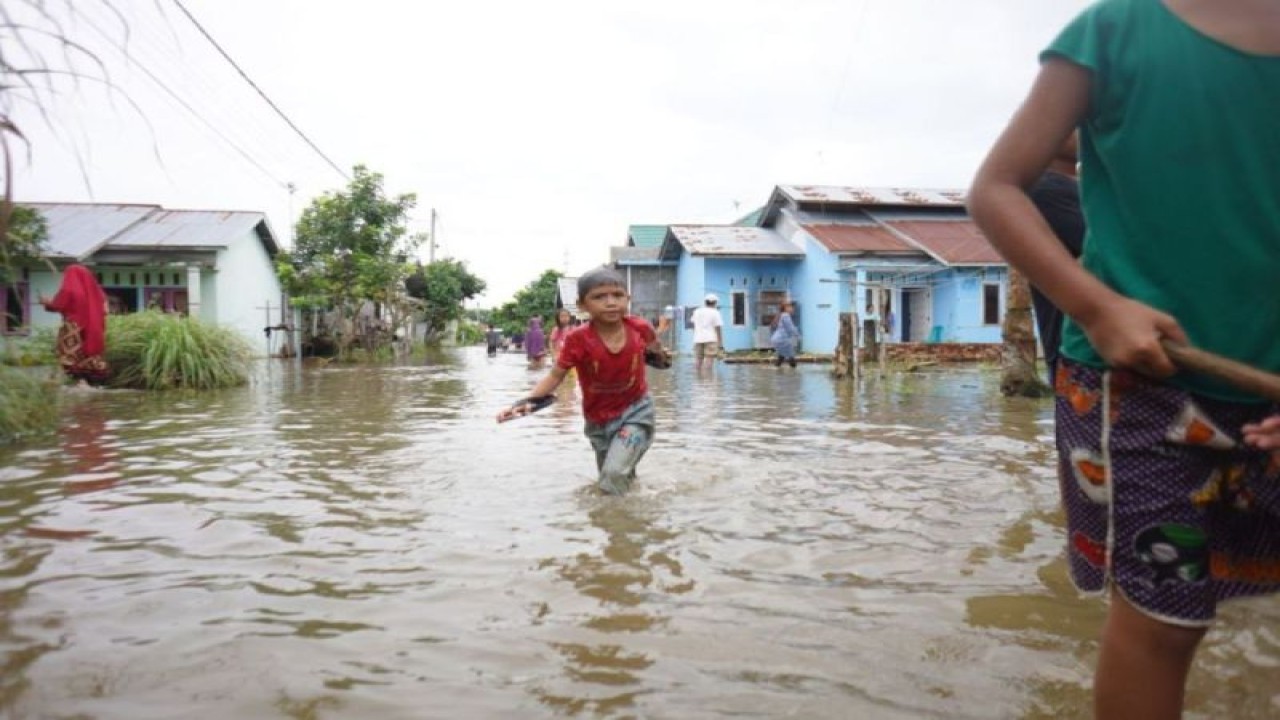 Bencana banjir yang kini melanda sejumlah daerah di Riau, nampak anak-anak bermaian air yang mengenangi jalan dan rumah mereka. ANTARA/HO-Humas BPBD Riau.