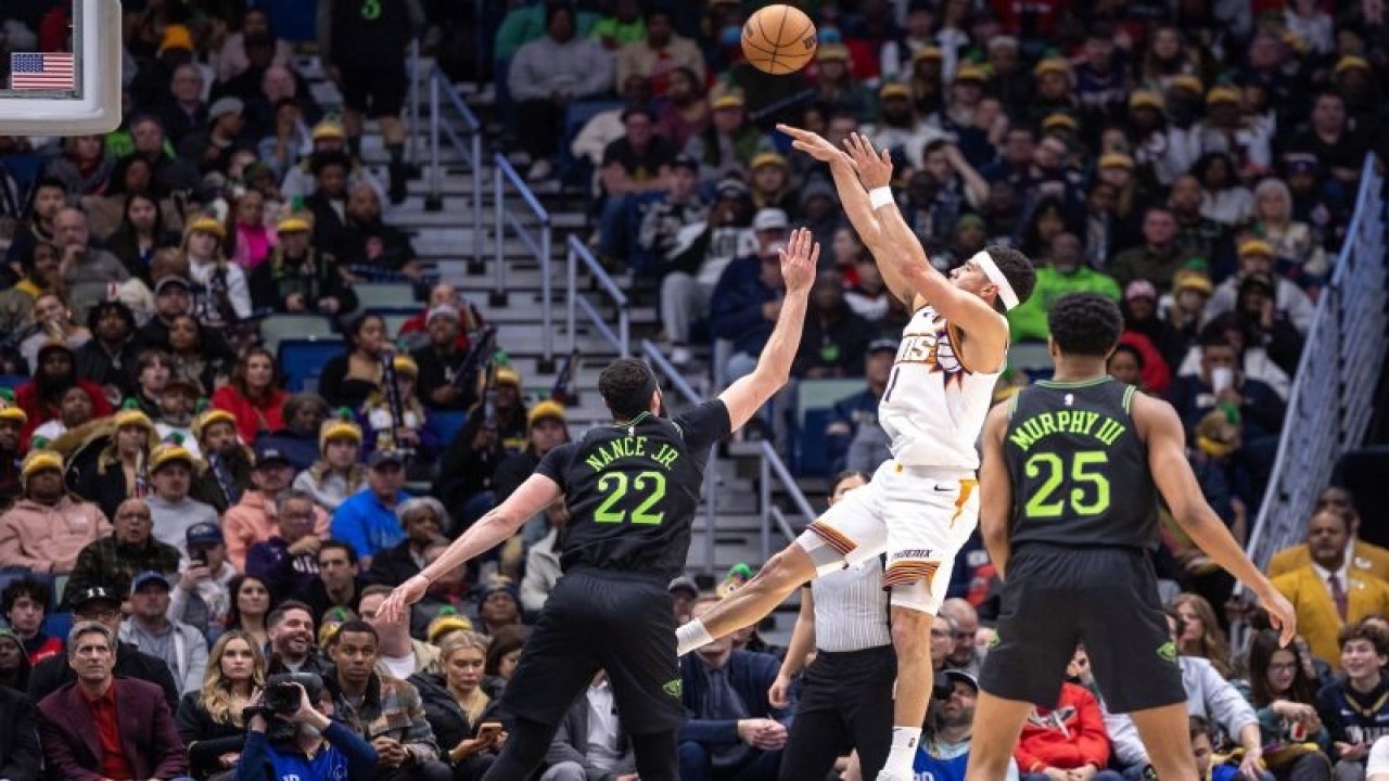 Pebola basket Phoenix Suns Devin Booker (tengah) melepas tembakan saat melawan New Orleans Pelicans dalam laga NBA di Smoothie King Center, New Orleans, Louisiana, AS, Jumat (19/1/2024). Suns menang dengan skor 123-109. ANTARA FOTO/USA TODAY Sports via Reuters Con/Stephen Lew/foc.
