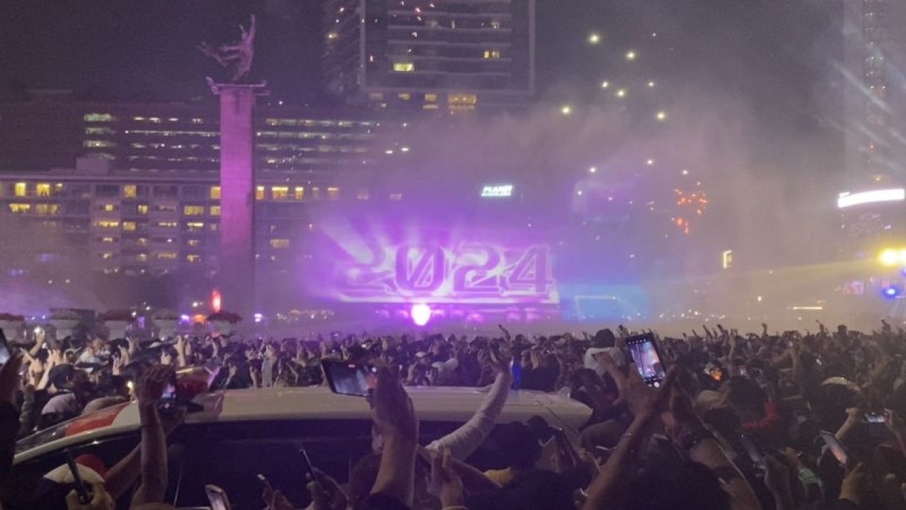 Sejumlah warga menonton atraksi 'video mapping' mewarnai malam pergantian tahun di kawasan Bundaran Hotel indonesia (HI), Jakarta, Minggu (31/12/2023). ANTARA/Arif Prada