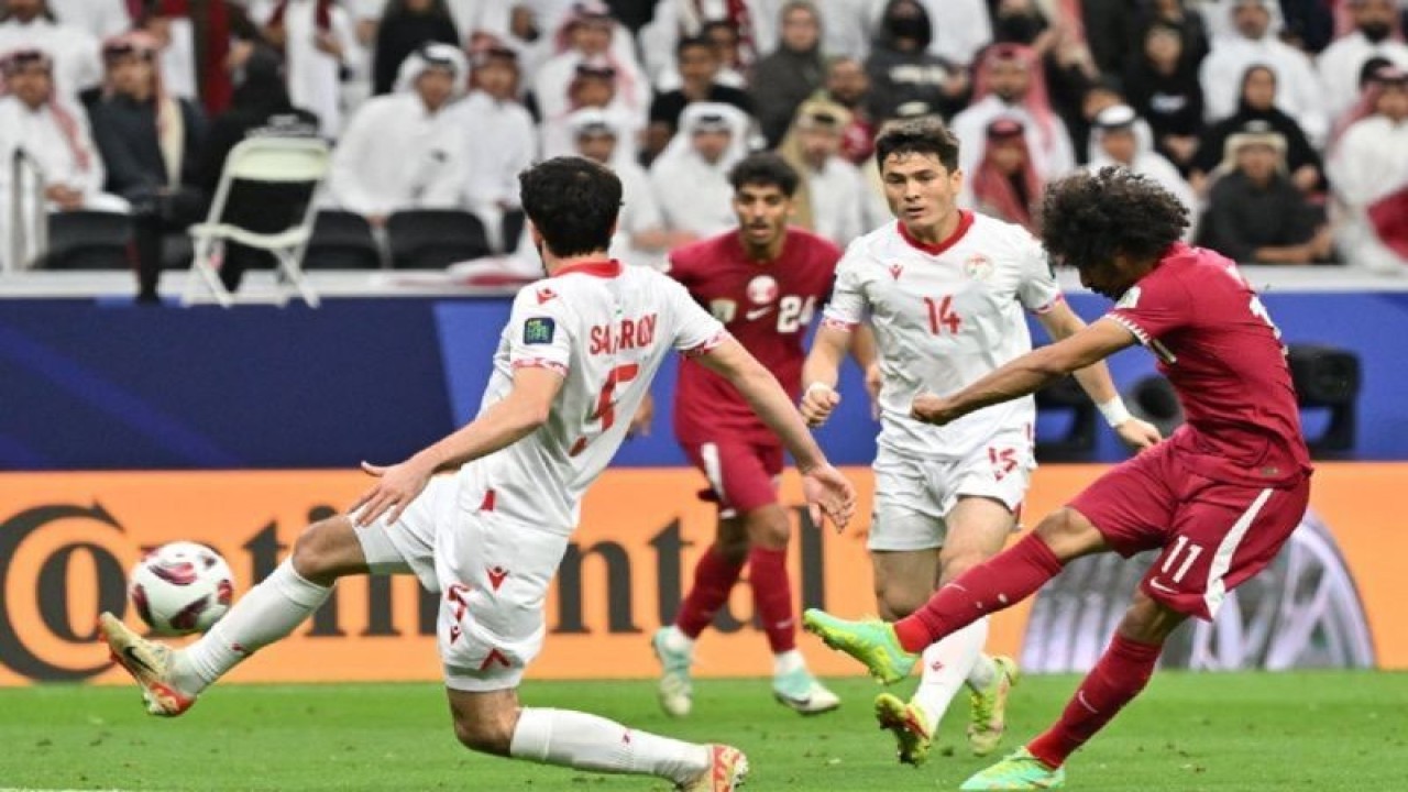 Penyerang Qatar Akram Afif (kanan) melepaskan tembakan pada pertandingan Grup A Piala Asia 2023 melawan Tajikistan di Stadion Al Bayt, Doha, Rabu (17/1/2024). (ANTARA/AFP/HECTOR RETAMAL)