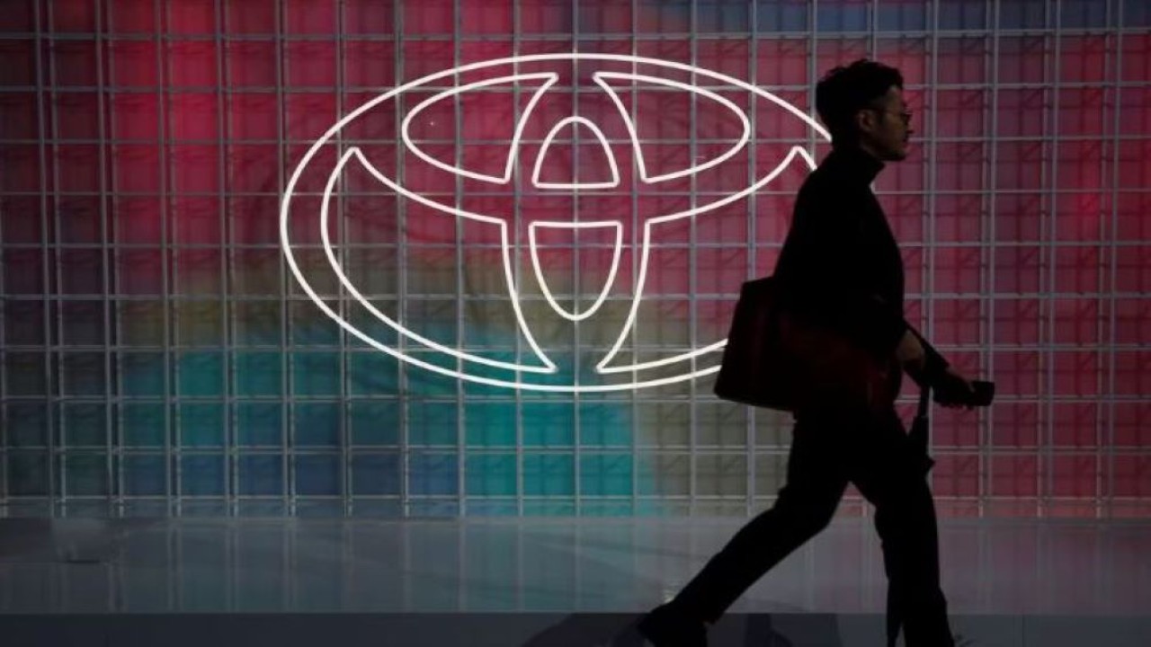 Seorang pria berjalan melewati logo Toyota di Tokyo Motor Show, di Tokyo, Jepang 24 Oktober 2019. (Dok/Edgar Su/Reuters)