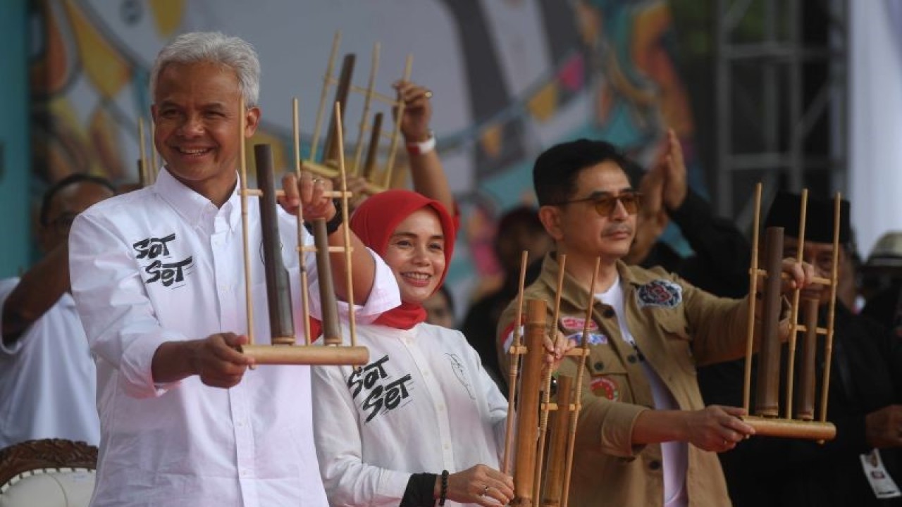 Calon presiden nomor urut 3 Ganjar Pranowo (kiri) bersama istri Siti Atikoh (tengah) dan Ketua Tim Pemenangan Nasional Arsjad Rasjid (kanan) memainkan angklung saat kampanye terbuka perdana bertajuk Hajatan Rakyat di Lapangan Tegalega, Bandung, Jawa Barat, Minggu (21/1/2024). Hajatan Rakyat yang merupakan singkatan dari harapan jutaan rakyat itu mengusung konsep merakyat seperti sosok Ganjar yang sederhana dan dekat dengan rakyat. ANTARA FOTO/Akbar Nugroho Gumay/wpa.