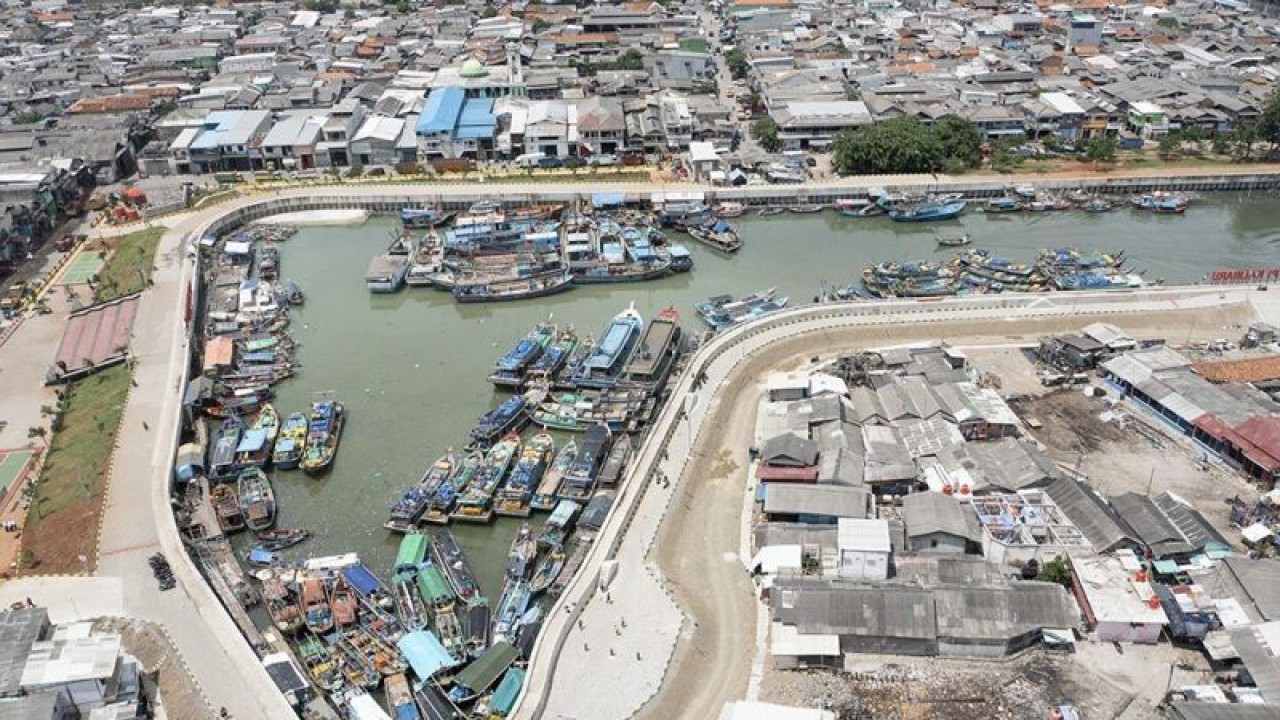 Foto udara sejumlah kapal motor bersandar di Tanggul Plaza Kalibaru, Cilincing, Jakarta Utara, Jumat (6/1/2023). Tanggul Plaza Kalibaru yang dilengkapi dengan polder kolam retensi dan baru selesai dibangun tersebut diharapkan dapat menahan kenaikan muka air laut (rob) dan mengendalikan meluapnya aliran air sungai baik yang diakibatkan tingginya intensitas hujan maupun aliran air kiriman. (ANTARA FOTO/M Risyal Hidayat/rwa.)
