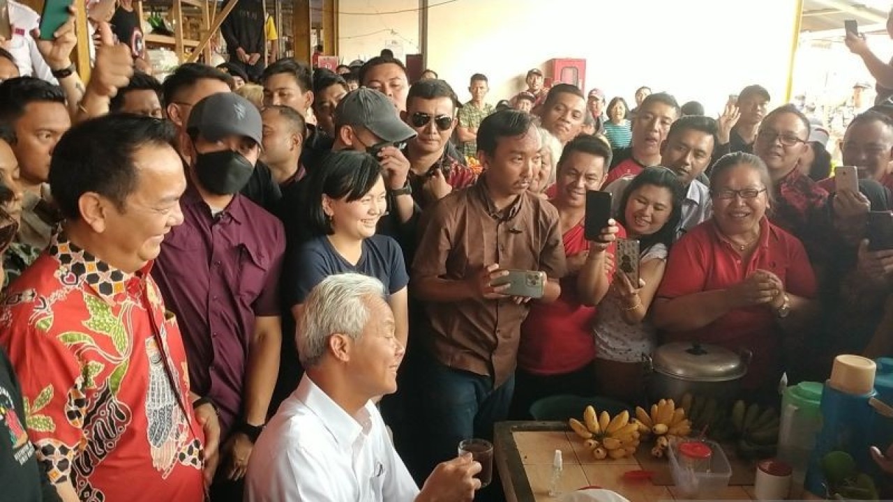 Capres Ganjar Pranowo saat menikmati kopi di Pasar Beriman Kota Tomohon dan disaksikan sejumlah warga, Kamis (1/2). (Foto ANTARA/Hannie)