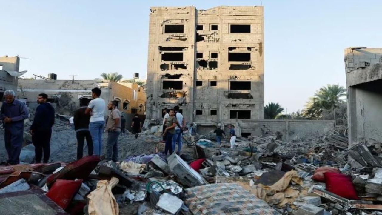 Warga Palestina melihat hancurnya sebuah rumah pasca serangan di tengah konflik dengan Israel di Khan Younis, di Jalur Gaza selatan, 12 Oktober 2023. (Ibraheem Abu Mustafa/Reuters)